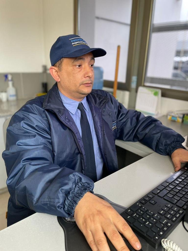 Personal de Proyección Seguridad, con uniforme de la empresa, frente a una computadora