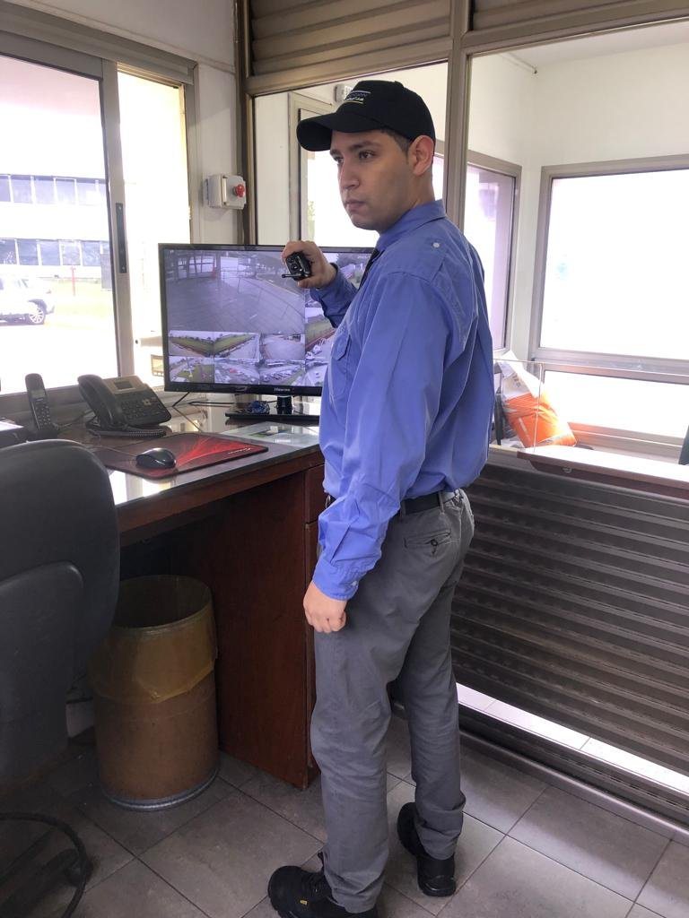 Vigilador de Proyección Seguridad en su puesto, junto al monitor de cámaras